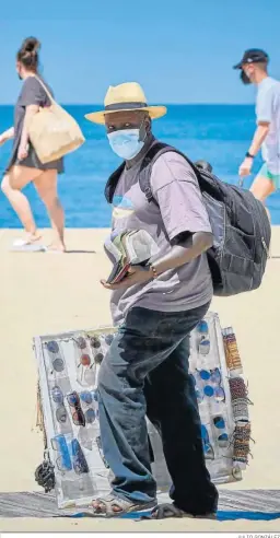  ?? JULIO GONZÁLEZ ?? Una vendedor camina por una playa de Cádiz.