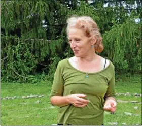  ??  ?? Dorothy Ernst explains the calming benefits of the stone labyrinth she created, which sits on the ground behind her.