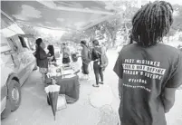  ?? WILFREDO LEE/AP ?? In this Oct. 22, 2018 photo, people gather around the Ben & Jerry’s “Yes on 4” truck as they learn about Amendment 4 and eat free ice cream at Charles Hadley Park in Miami.