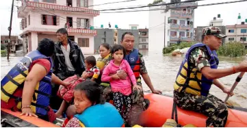  ??  ?? Nepalese Army rescue locals on a dinghy in a flooded neighbourh­ood after incessant rainfall in Bhaktapur, Nepal. — Reuters photo