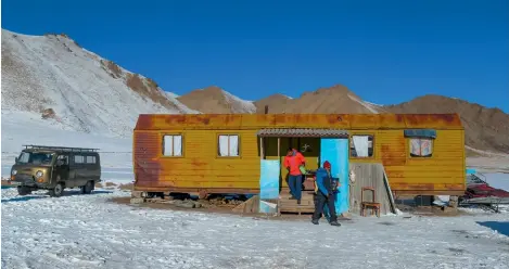  ??  ?? A dilapidate­d train wagon stationed on a white expanse of snow doubles as a residence in Kel Suu village.