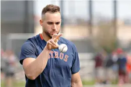 ?? AP Photo ?? ■ Houston Astros outfielder George Springer reaches for a ball after tossing it in the air during spring training baseball practice Thursday in West Palm Beach, Fla.