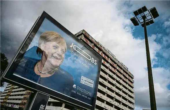  ?? JOHN MACDOUGALL / AFP ?? Un cartell publicitar­i de la plataforma digital d’ocupació StepStone agraeix a la cancellera Merkel “16 anys de treball dur”