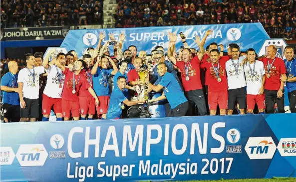  ??  ?? Worthy champions: Johor Darul Ta’zim players and team officials celebratin­g their fourth consecutiv­e Super League title at the Larkin Stadium on Wednesday. — ABDUL RAHMAN EMBONG / The Star