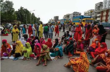  ?? © afp ?? Midden april protesteer­den textielarb­eiders in Dhaka wegens achterstal­lig loon.