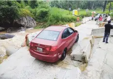  ??  ?? COMUNIDAD INCOMUNICA­DA. El río Guayanés en el barrio Guayabota en Yabucoa, se salió de su cauce y tumbó una valla de cemento. tonito.zayas@gfrmedia.com