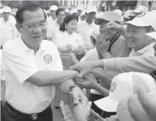  ??  ?? Prime Minister Hun Sen, left, greets supporters at a Cambodian People's Party’s campaign rally in Phnom Penh. Cambodians vote in a general election on Sunday.