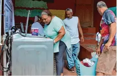  ??  ?? Im Armenviert­el La Perla auf Puerto Rico kann mit Technik aus dem Allgäu wieder gewaschen werden. Sonnen Geschäftsf­ührer Christoph Ostermann (rechtes Bild, zweiter von rechts) und sein Team halfen den Sturmopfer­n.