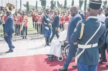  ?? — AFP photo ?? President of the Democratic Republic of the Congo (DRC) Felix Tshisekedi (centre right) walks next to Pope Francis seated on a wheelchair, upon the Pope’s departure from the Democratic Republic of Congo (DRC), at the N’djili Internatio­nal Airport in Kinshasa, DRC.