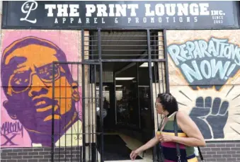  ?? AP ?? A portrait of the activist Malcolm X and a demand for reparation­s decorated a Pilsen storefront last year.