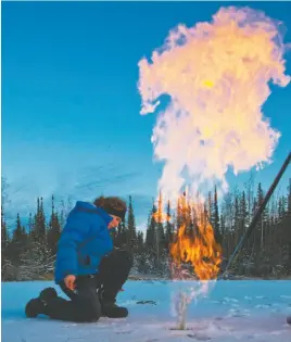  ?? UNIVERSITY OF ALASKA, FAIRBANKS HANDOUT PHOTO; VIA AP ?? This handout photo, taken in 2009, provided by University of Alaska, Fairbanks, shows research assistant professor Katey Walter Anthony igniting trapped methane from under the ice in a pond on the Fairbanks campus.