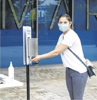  ?? NURIA SOLER ?? Una mujer se limpia las manos antes de entrar en una tienda de un centro comercial, en Zaragoza.