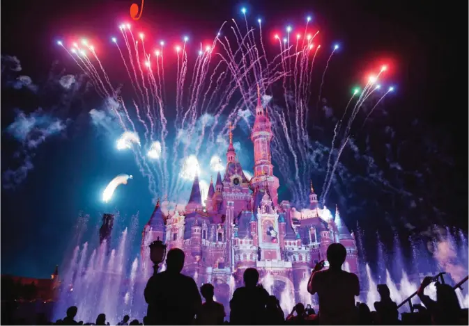  ??  ?? This photo taken on June 16, 2017 shows visitors watching fireworks exploding over the castle at an event to mark the first anniversar­y of the opening of Shanghai Disneyland, in Shanghai. — AFP