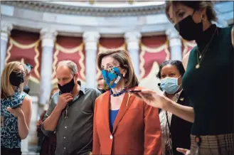  ?? J. Scott Applewhite / Associated Press ?? House Speaker Nancy Pelosi, D-Calif., walks to the chamber for a vote, joined at left by actor Woody Harrelson, at the Capitol in Washington on Wednesday.