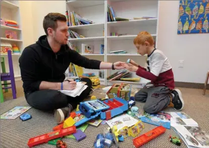  ??  ?? Behavioura­l therapist Kevin Brimer works with Gabe Pellegrini at the newly opened New Heights Learning, which offers help for youth with autism.