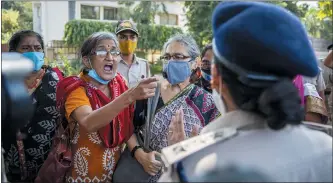  ?? PHOTOS BY ALTAF QADRI — THE ASSOCIATED PRESS ?? An Indian activist argueswith a police officer before being detained by police during a protest in New Delhi, India, Wednesday. The gang rape and killing of the woman from the lowest rung of India’s caste system has sparked outrage across the country with several politician­s and activists demanding justice and protesters rallying on the streets.