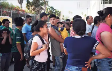  ?? Emilio Espejel / Associated Press ?? Migrants line up in Matamoros, Mexico, for a meal donated by volunteers from the U.S., at the foot of the Puerta Mexico bridge that crosses to Brownsvill­e, Texas. Some asylum seekers were told by officials on Friday, that the U.S. government may reopen their cases and they would eventually be able to enter the U.S. to wait out the asylum process.