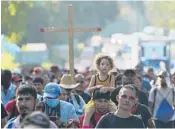  ?? MARCO UGARTE/AP ?? A caravan of migrants heads north Sunday along a coastal highway outside Huehuetan, Mexico.