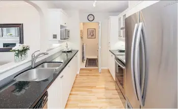  ??  ?? The kitchen at 204-12633 No. 2 Road in Richmond features white cabinets and stainless steel appliances.