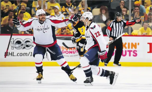  ?? — GETTY IMAGES ?? Washington Capitals defenceman Kevin Shattenkir­k, right, celebrates with captain Alex Ovechkin, left, after scoring an overtime goal to beat the Pittsburgh Penguins 3-2 in Game 3 on Monday in Pittsburgh. The Penguins lead the series 2-1.