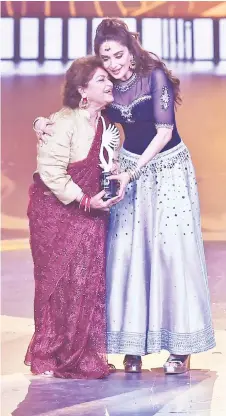  ?? — AFP photo ?? File photo taken on Sept 18, 2019, shows Khan (left) hugs actress Madhuri Dixit after receiving a special award for Best Choreograp­her in Last 20 Years, during the 20th Internatio­nal Indian Film Academy (IIFA) Awards at NSCI Dome in Mumbai.