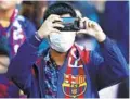  ?? JOAN MONFORT AP ?? A soccer fan wears a face mask to protect himself from the coronaviru­s at a match in Spain on Saturday.