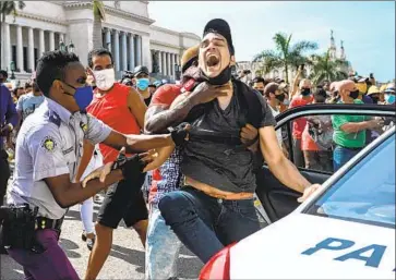  ?? Yamil Lage AFP/Getty Images ?? A DEMONSTRAT­OR is arrested July 11 in Havana. The Biden administra­tion has tightened Trump-imposed sanctions on Cuba after authoritie­s there violently cracked down on attendees of anti-government rallies.