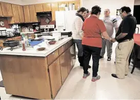  ?? Elizabeth Conley / Houston Chronicle ?? Debra McCammon, director of Hospitalit­y House, leads a group in prayer before dinner on Oct. 30. Hospitalit­y House, which offers free lodging and meals to families visiting inmates in Huntsville, is funded through donations.