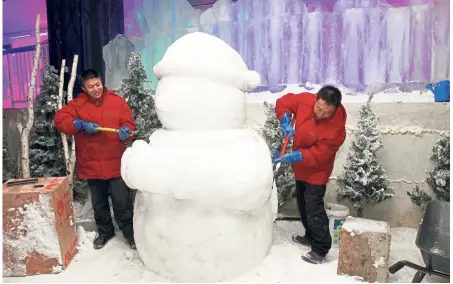  ??  ?? Ice sculptors from China working on a snow sculpture. — Photos: SHAARI CHEMAT/The Star