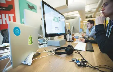  ?? Bloomberg ?? Workers at Shopify’s headquarte­rs in Toronto, Ontario. The Canadian company provides websites, payments, shipping and more for 500,000-plus online merchants and, less than three years after going public, has a market cap of $10 billion.