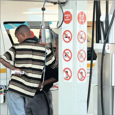  ?? PHOTO: IHSAAN HAFFEJEE ?? A taxi driver holds cash for fuel in his hands in this file photo, as a pump attendant fills his vehicle with petrol in anticipati­on of the fuel price increase.