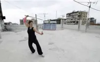  ??  ?? Lebanese public sector employee Anna Belle Shadarevia­n practices Tai Chi Chuan on the rooftop of her building.