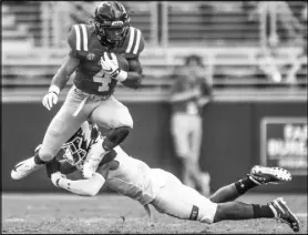  ?? Bruce Newman The Associated Press ?? Mississipp­i running back Tylan Knight eludes Kent State cornerback Jamal Parker during the Rebels’ 38-17 win Saturday.