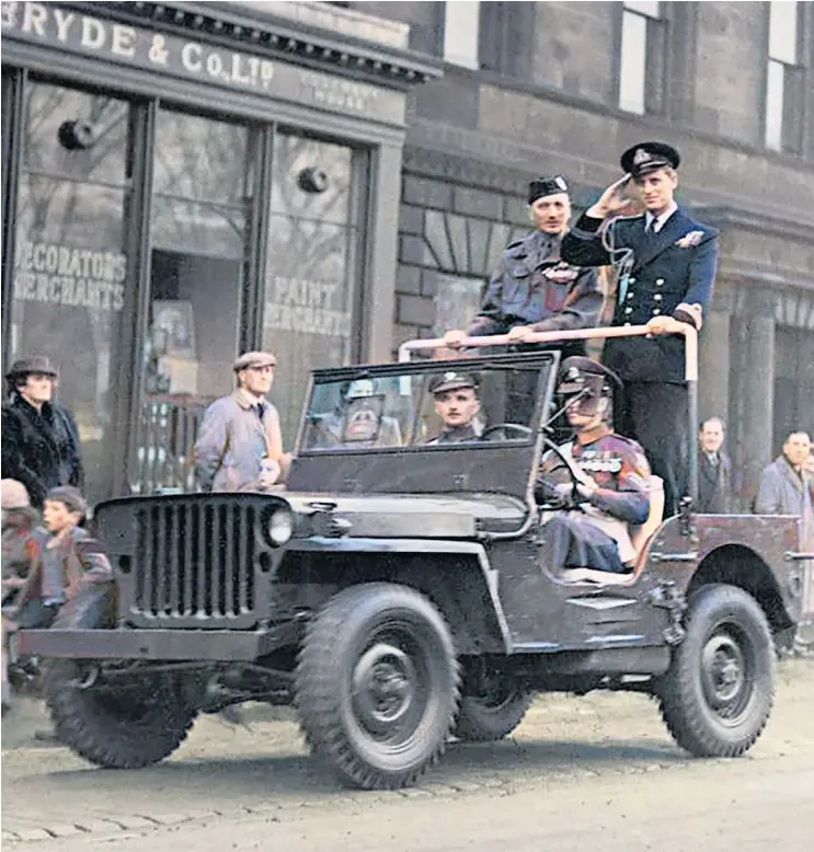 ??  ?? In this photograph with colour added, the Duke salutes as he travels through Edinburgh on a military light utility vehicle in 1948