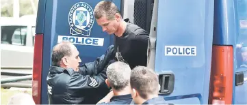  ??  ?? Vinnik (centre) is escorted by police officers as he arrives at a courthouse in Thessaloni­ki. — AFP photo