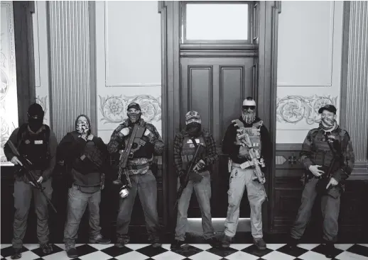  ??  ?? Members of a militia group outside the office of Michigan governor Gretchen Whitmer during a protest against her Covid stay-at-home order, Lansing, April 30, 2020. Three of them were later charged with being involved in a plot to kidnap her, attack the state capitol building, and incite violence.