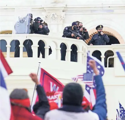  ?? JOHN MINCHILLO/AP ?? Supporters loyal to President Donald Trump clash with authoritie­s before breaching the Capitol on Jan. 6.