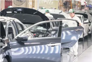  ?? PATTANAPON­G HIRUNARD ?? Workers carry out tasks on the assembly line of a car factory in Prachin Buri province. The OIE expects the MPI to grow by 4-5% this year.