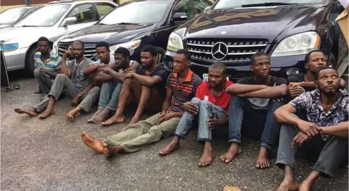  ??  ?? The arrested 10-man armed robbery gang with their stolen vehicles