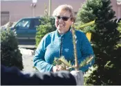  ??  ?? TOP: Trudy Spray smiles while purchasing a Christmas tree from Delancey Street’s sale at the corner of Paseo de Peralta and Old Santa Fe Trail. ‘We need more of that here,’ she said when she learned of Delancey Street’s mission.