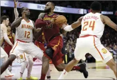  ?? DEJAK AP PHOTO/TONY ?? Cleveland Cavaliers’ LeBron James (23) drives against Atlanta Hawks’ Taurean Prince (12) and Kent Bazemore (24) in the second half of an NBA basketball game Sunday in Cleveland.