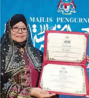  ?? (Foto Aizuddin Saad /BH) ?? Siti Zainon menunjukka­n watikah Anugerah Sastera Negara ke-14 yang membawa gelaran Sasterawan Negara pada Majlis Pengurniaa­n Anugerah Sastera Negara ke-14 di Kuala Lumpur.