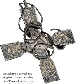  ??  ?? An Anglo-Saxon silver pectoral cross with a fine spiral suspension chain wrapped around it. Symbols of the four evangelist­s carved into each arm of the cross are detailed with niello inlay and gold-leaf
