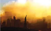  ?? AP PHOTO/DAN LOH ?? The Statue of Liberty stands in front of a smoldering lower Manhattan at dawn, seen from Jersey City, N.J., on Sept. 15, 2001.