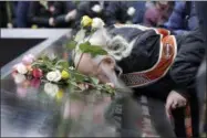  ?? RICHARD DREW — THE ASSOCIATED PRESS ?? Ed Schantz, representi­ng Monica Rodriguez Smith and her unborn daughter, two of the six victims of the World Trade Center bombing, kisses her name on the 9/ 11Memorial during the 25th anniversar­y ceremony of the event, in New York, Monday.
