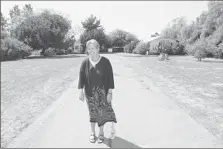  ?? Don Leach
Daily Pilot ?? KATHY ANDERSON
walks down the original driveway of the Tustin Avenue property her parents bought in the 1940s.