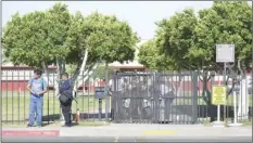  ??  ?? Calexico High School security guards open the door to a person leaving the school Thursday afternoon. The school was in lockdown after three students were arrested for carrying a toy gun earlier in the day. MARIO RENTERIA PHOTO