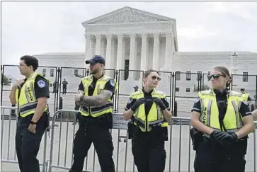  ?? Jose Luis Magana Associated Press ?? CAPITOL POLICE watch a protest at the high court. Justice Sotomayor said of Tuesday’s ruling, “This court continues to dismantle the wall of separation between church and state that the framers fought to build.”