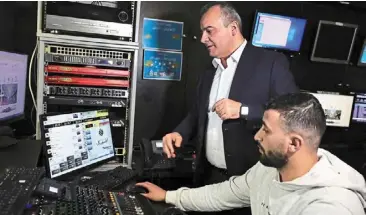  ?? — AFP ?? Walid (left) talking to a Radio Ajyal staff member on Feb 9, 2024.