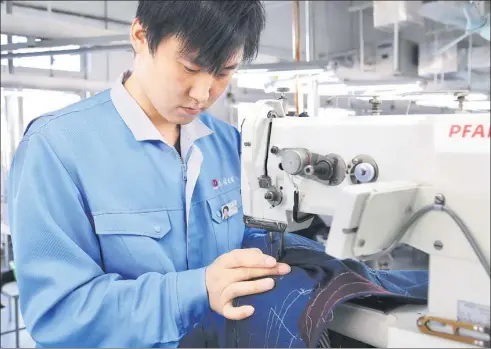  ?? CHANG XIAOCHAO / FOR CHINA DAILY ?? A worker operates a high-end sewing machine at an intelligen­t fabric-cutting workshop of Dayang Group Co Ltd in Dalian, Liaoning province.